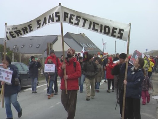 Le dimanche 25 mars 2012, des marcheurs défilent à Plomeur, dans le finistère, avec des banderolles demandant l'acceptation d'une terre désormais sans pesticides.  JPEG - 44.6 ko